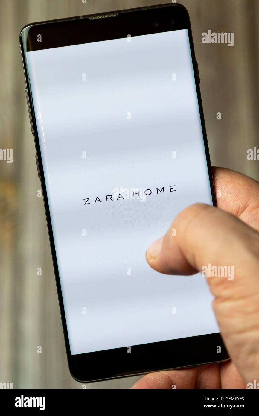 A mobile phone or cell phone being held by a hand with the Zara Home app  open on screen Stock Photo - Alamy