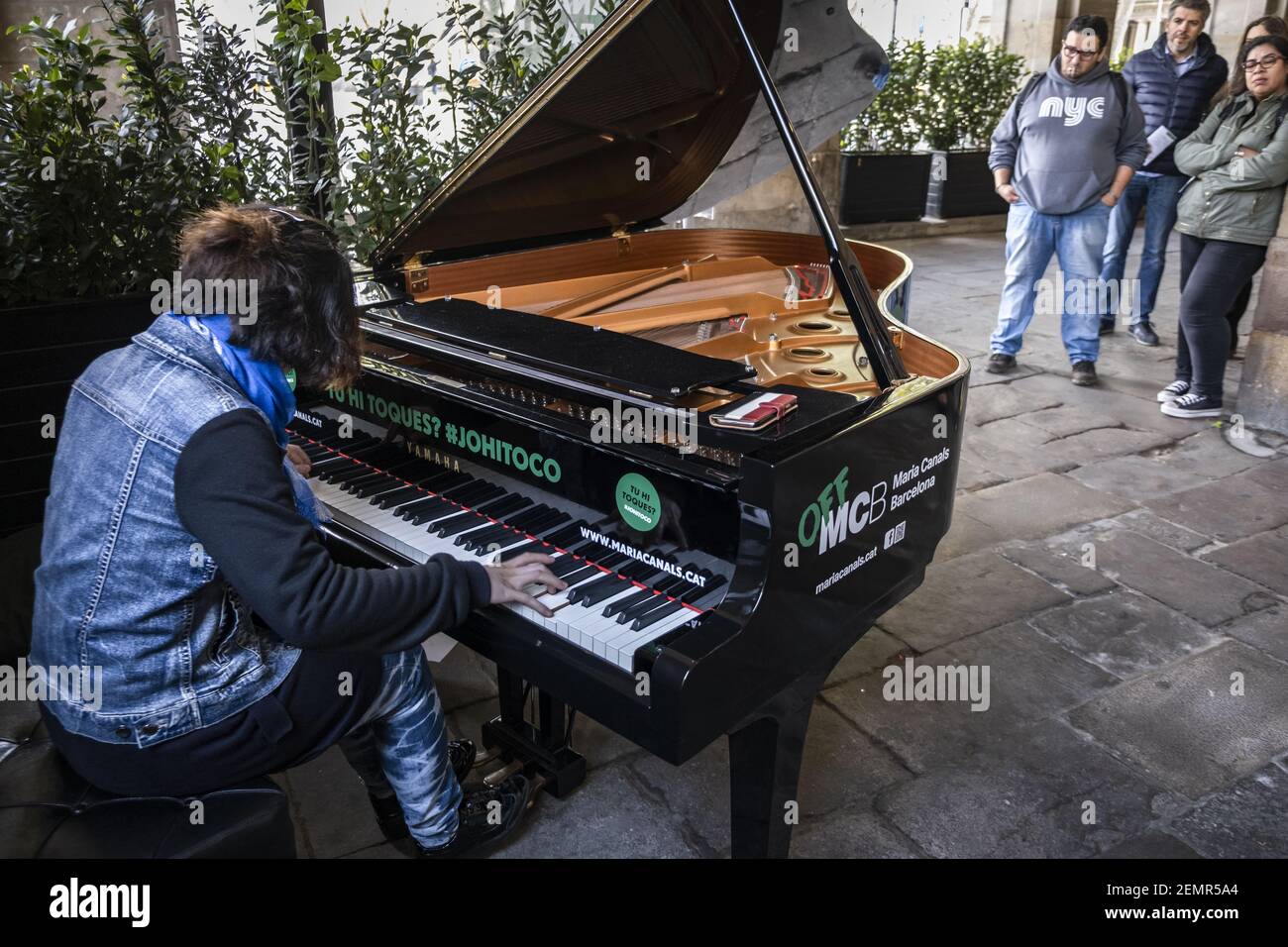 A young pianist woman is seen playing a grand piano in the arches d'En  Xifré in front of the famous restaurant 7Portes. Grand pianos have been  placed in various public spaces of