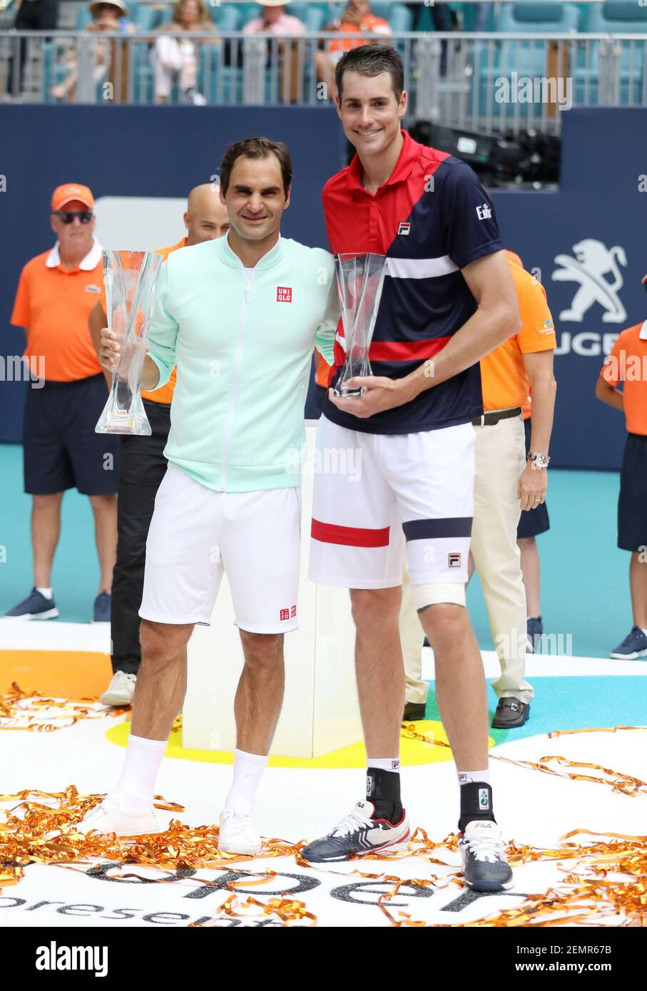MIAMI GARDENS, FLORIDA - MARCH 31: Roger Federer of Switzerland and John  Isner pose for photographers at the trophy ceremony during the men's final  of the Miami Open Presented by Itau at