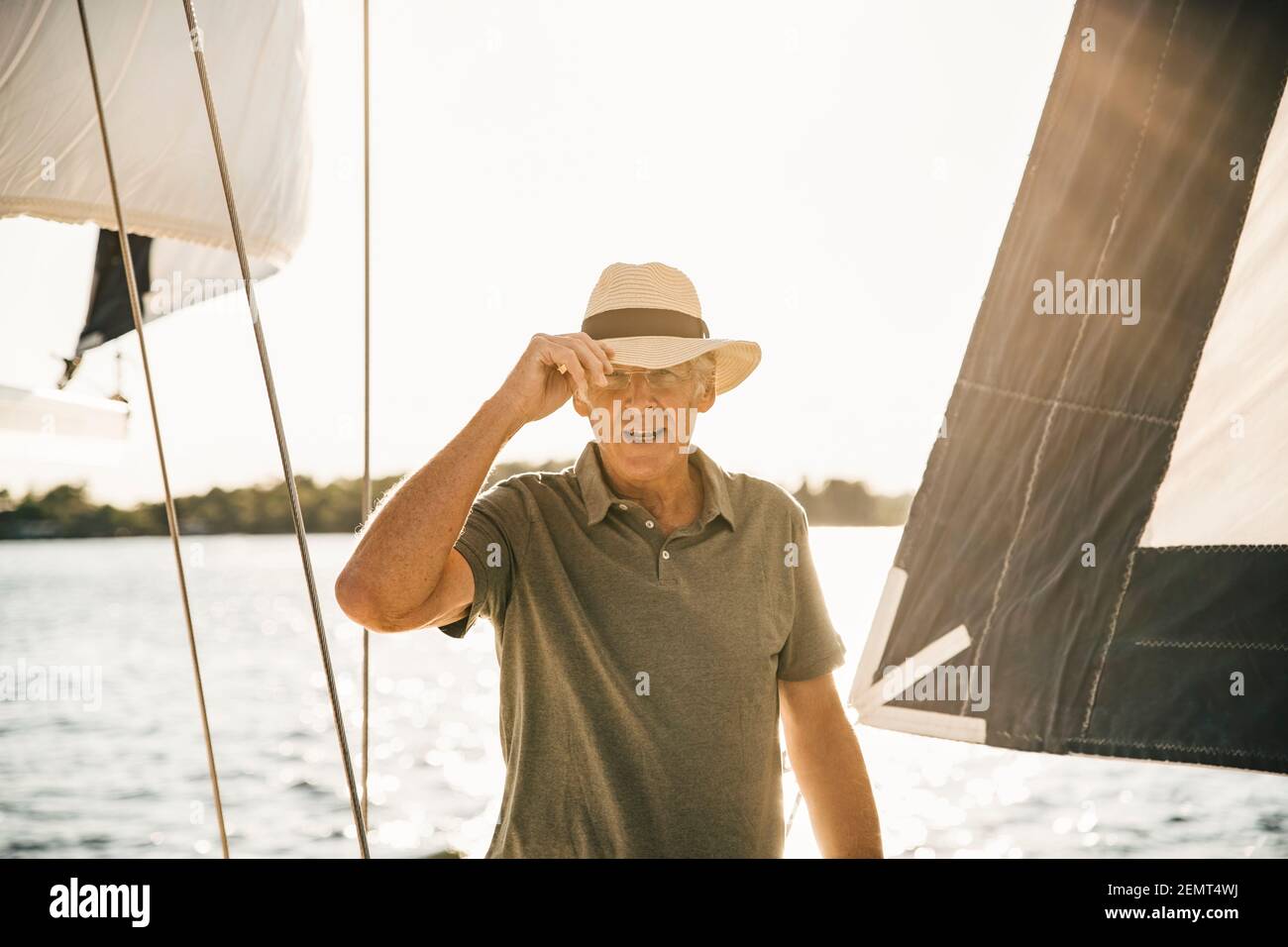 Portrait of senior man with hat in boat on sunny day Stock Photo
