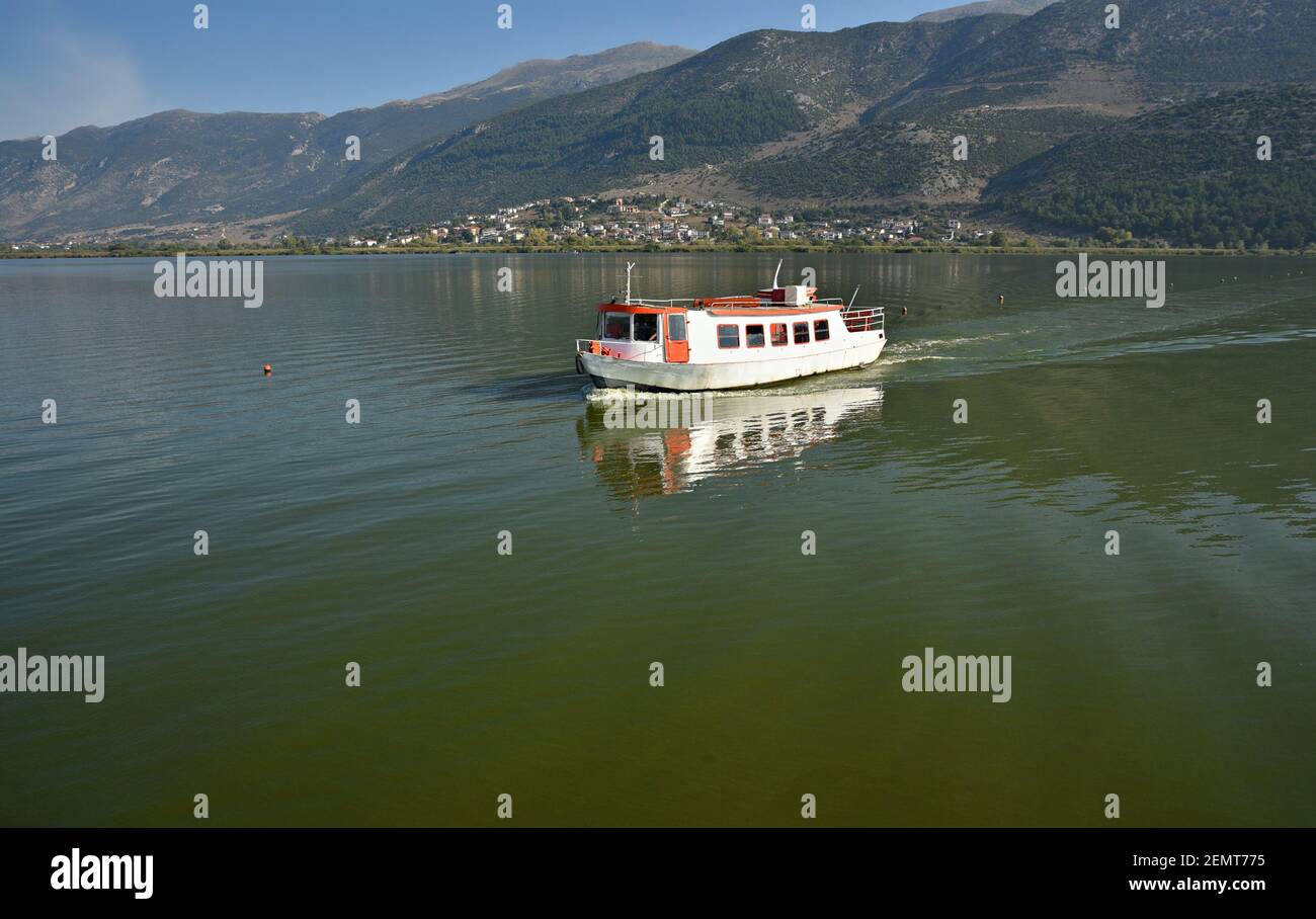 Landscape with a traditional tour boat on Pamvotis Lake in Ioannina, Epirus Greece. Stock Photo