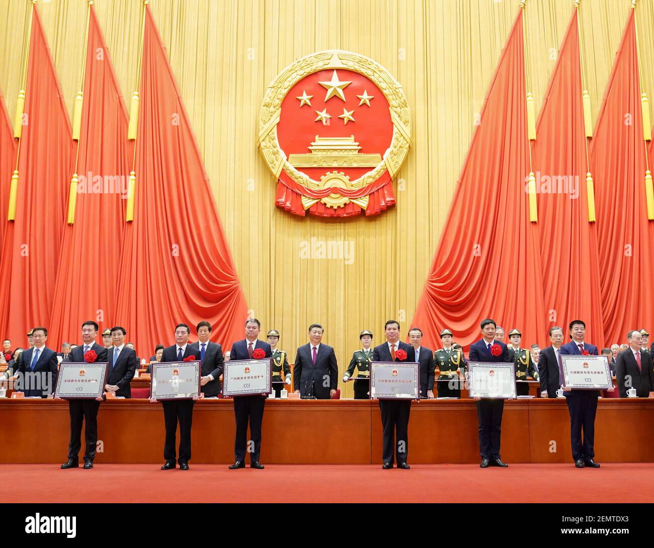 Beijing, China. 25th Feb, 2021. Chinese President Xi Jinping, also general secretary of the Communist Party of China Central Committee and chairman of the Central Military Commission, presents awards to individuals and groups for their outstanding achievements in the fight against penury during a grand gathering to mark the nation's poverty alleviation accomplishments and honor model poverty fighters at the Great Hall of the People in Beijing, capital of China, Feb. 25, 2021. Credit: Yan Yan/Xinhua/Alamy Live News Stock Photo
