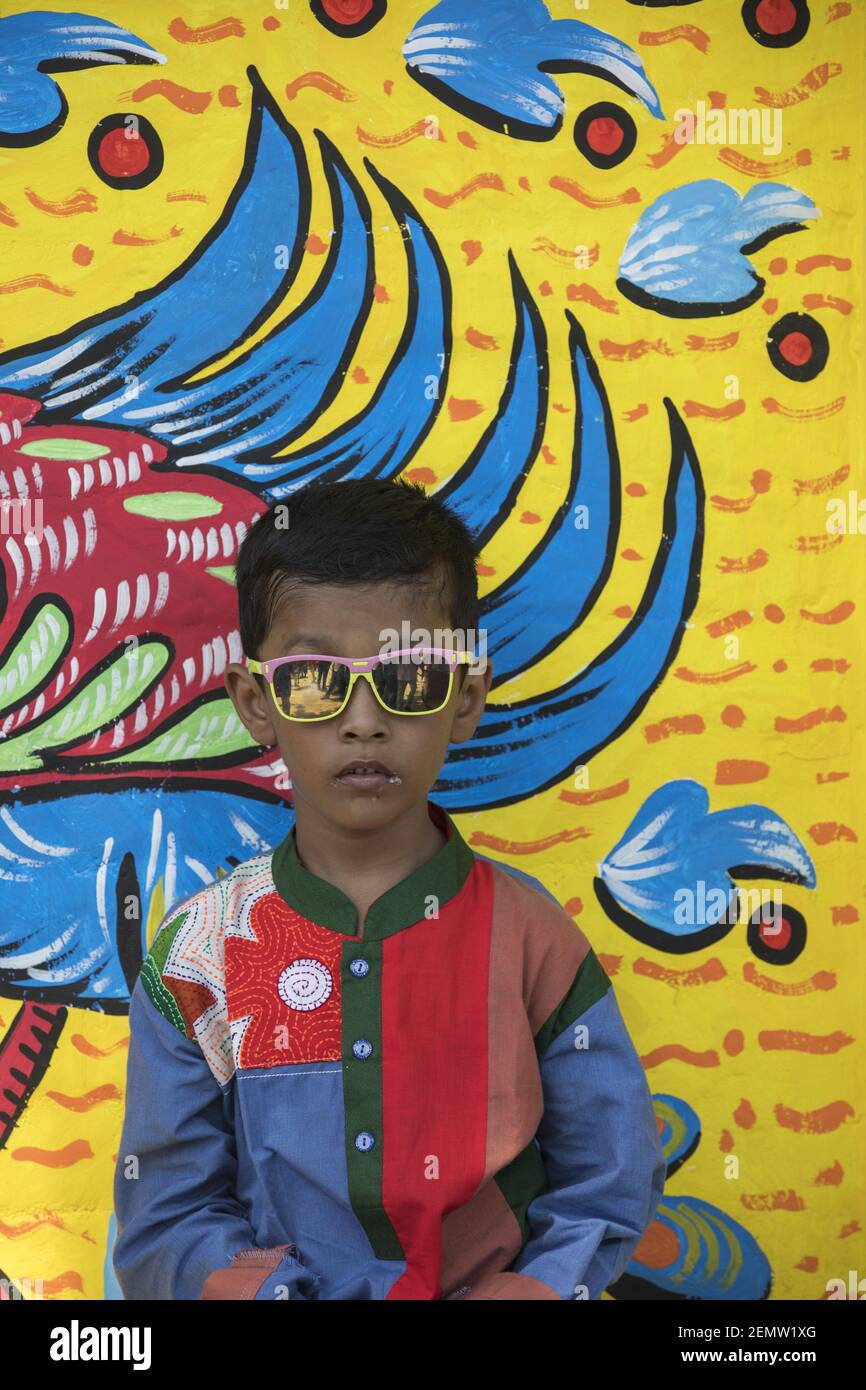 Bangladeshi woman pose for a portrait infront of wall paint to