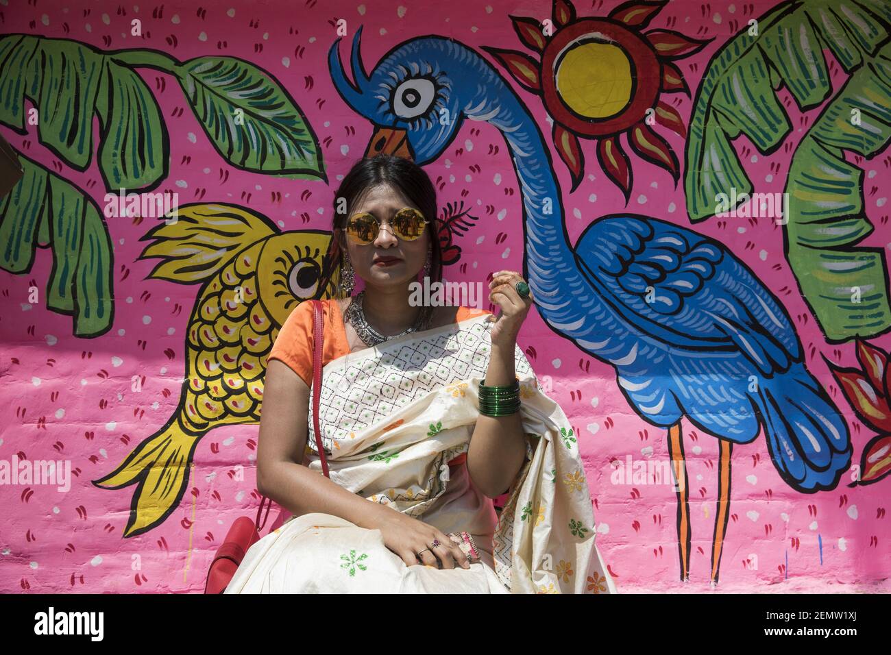Bangladeshi woman pose for a portrait infront of wall paint to