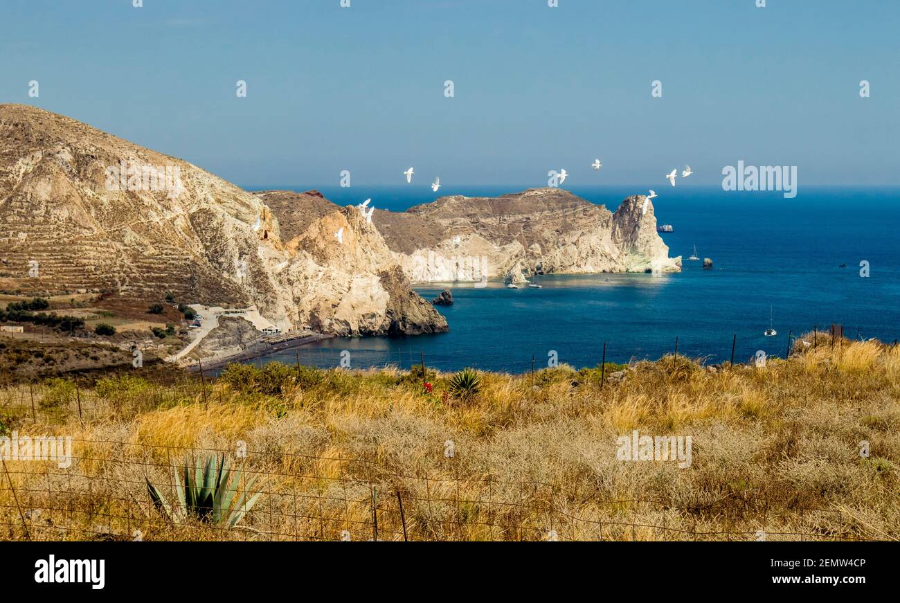 Famous White beach on island of Santorini, Greece. Seen from distance. Beautiful nature landscape, white bird flock fly. Stock Photo