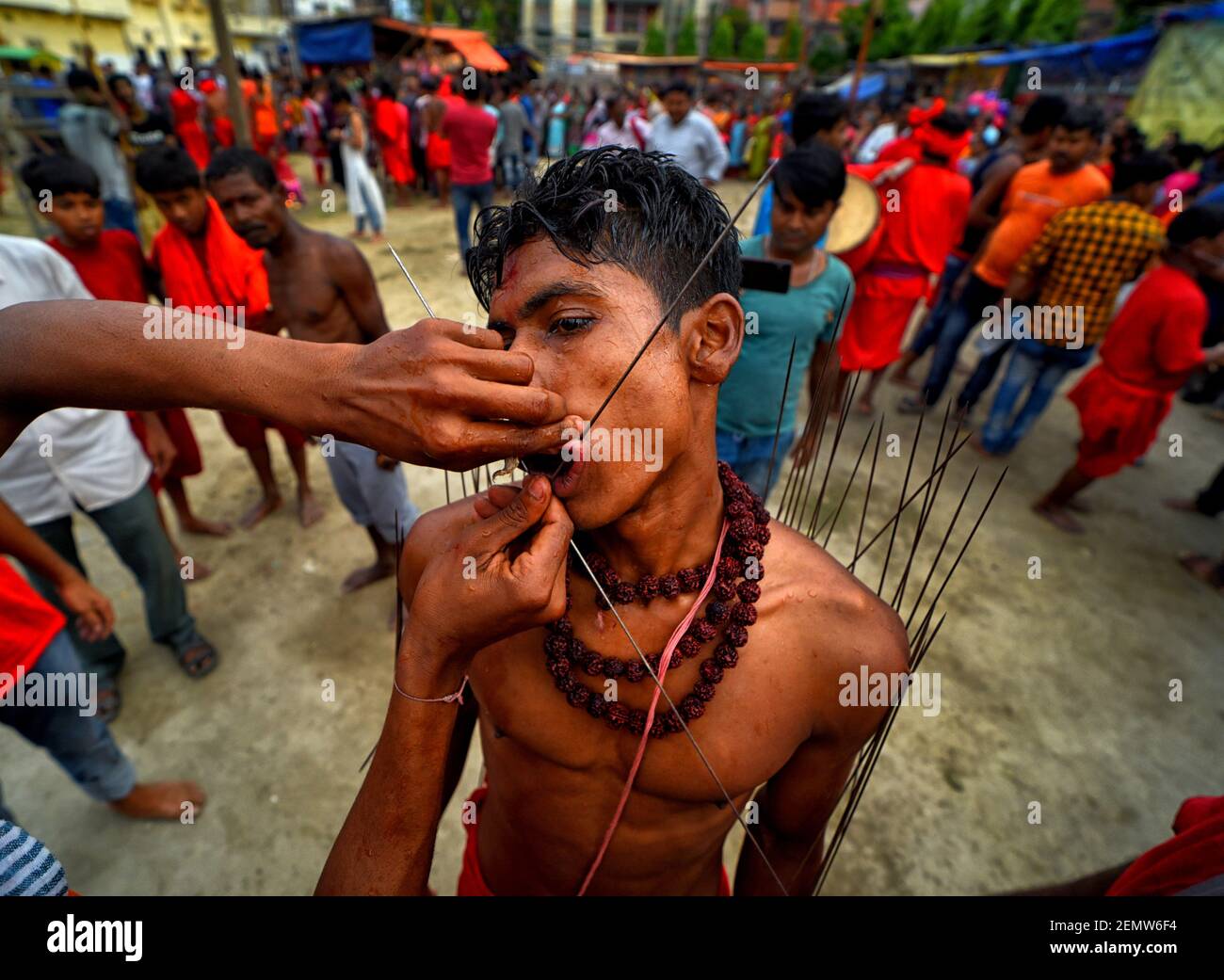 Hindu devotees seen being pierced his face with sharp needles as per the  traditional ritual of giving pain to self during Charak Festival. Charak  Festival is one of the oldest Folk festival