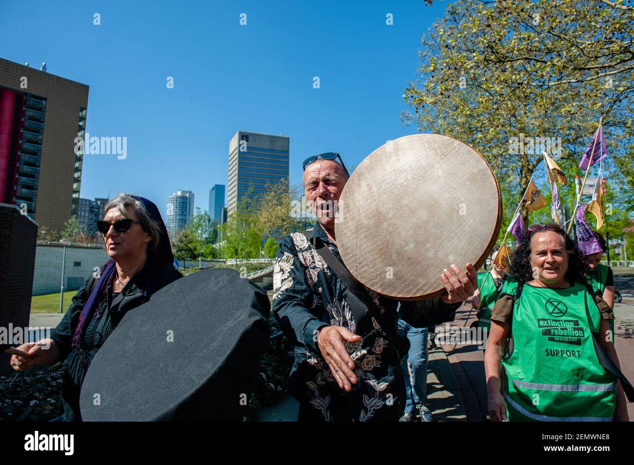 An activist is seen playing a bodhran while shouting slogans during the protest. A funeral