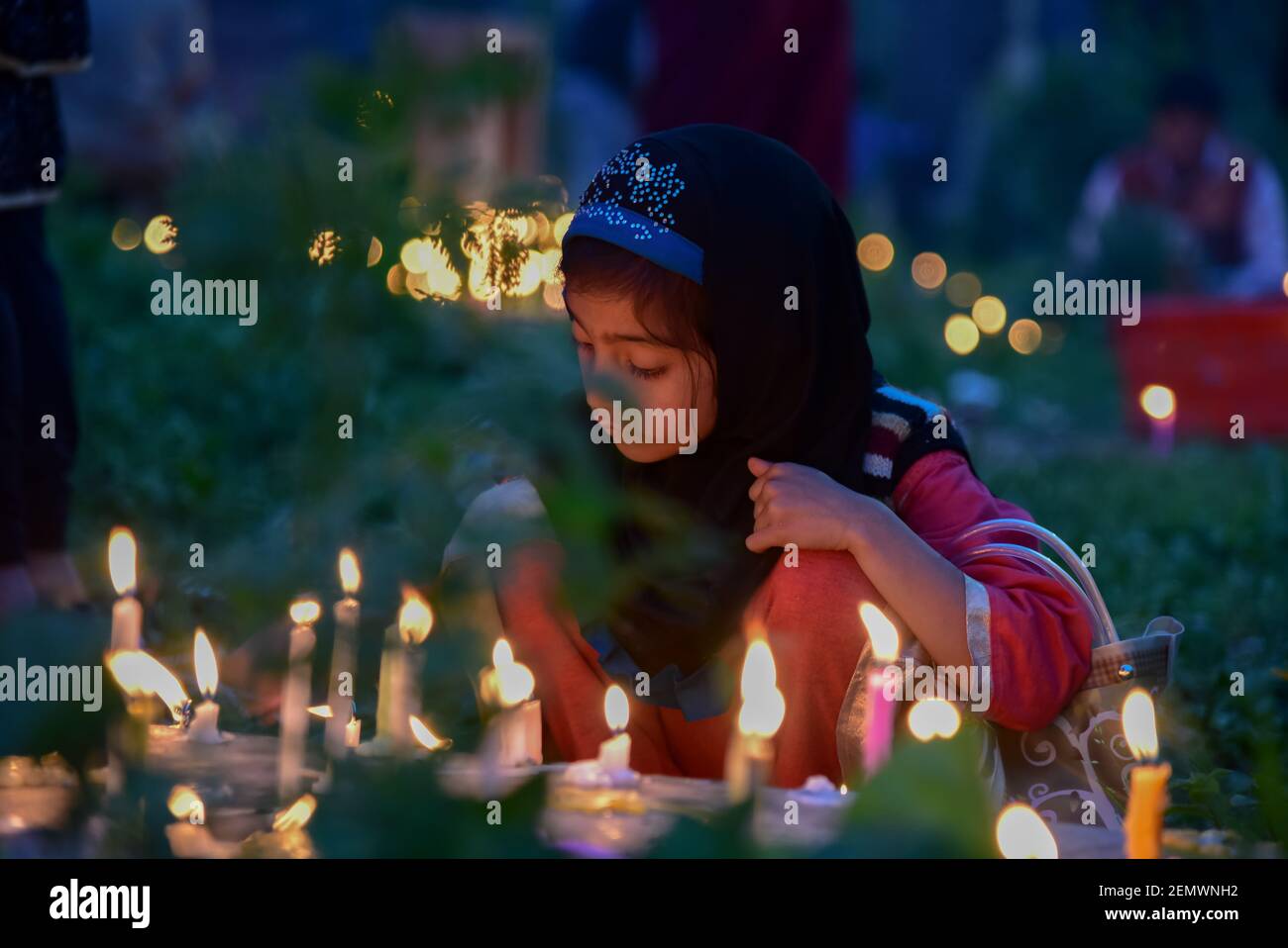 A Kashmiri Shia Muslim girl seen lighting candles on the grave of her relatives during the Shab-e-Barat occasion in Srinagar. Every year, Shab-e- Barat is observed on the night between 14th and 15th A Kashmiri Shia Muslim girl seen lighting candles on the grave of her relatives during the Shab-e-Barat occasion in Srinagar. Every year, Shab-e- Barat is observed on the night between 14th and 15th