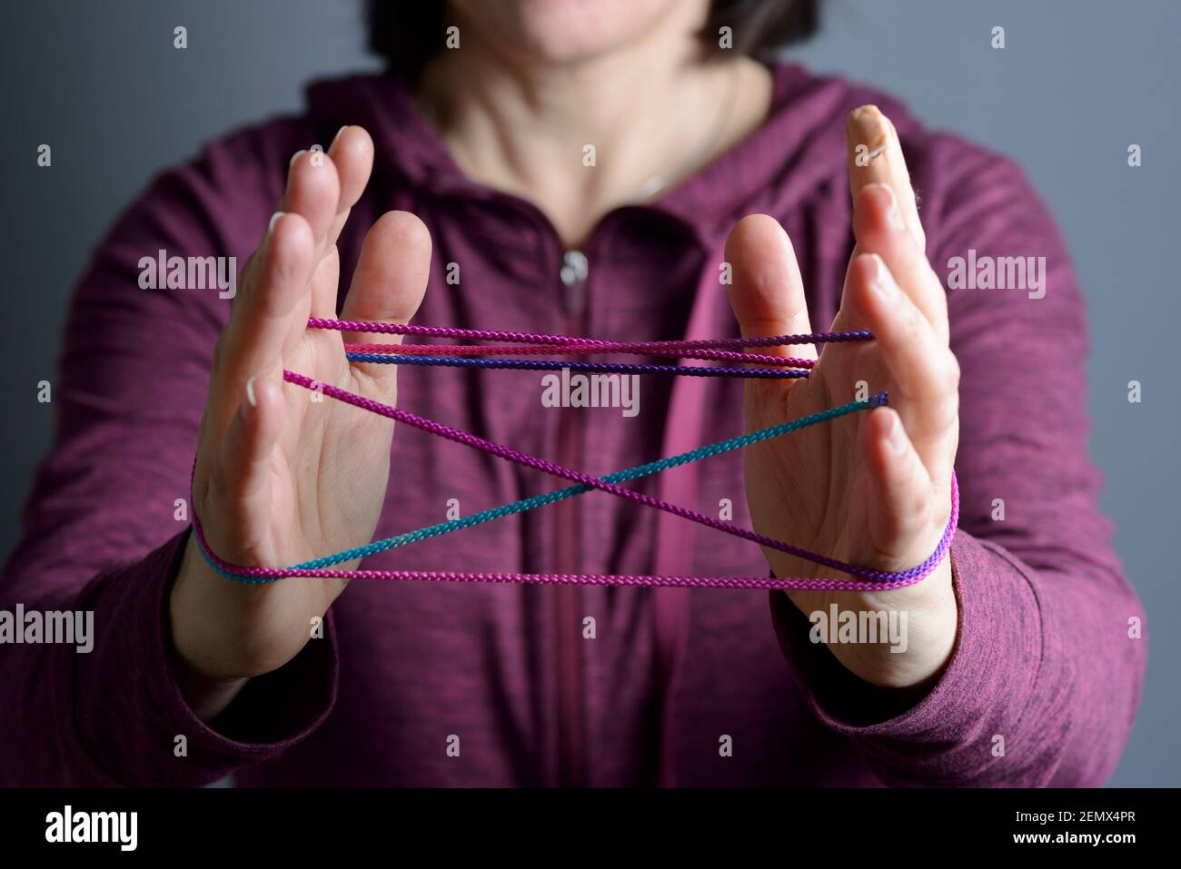 Young woman playing cat's cradle Stock Photo