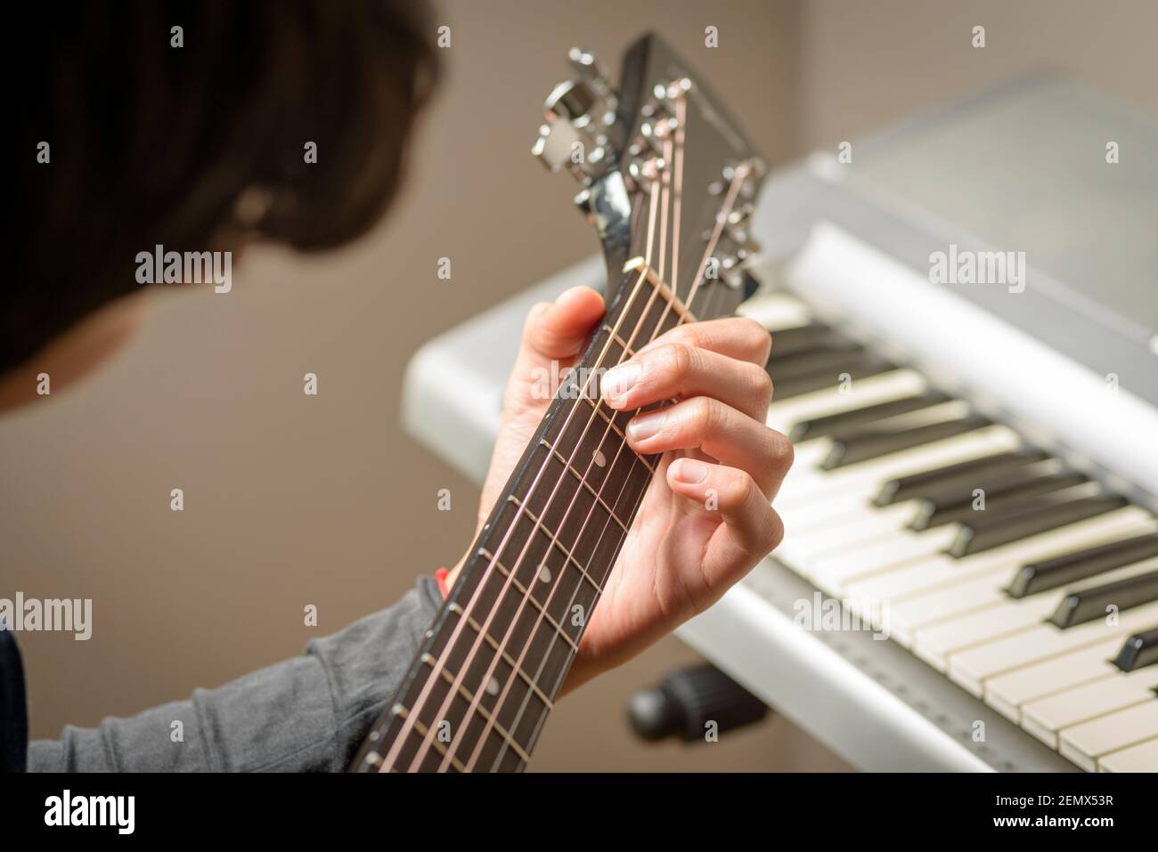 Close-up of teenage boy playing chords on acoustic guitar,London,UK Stock Photo