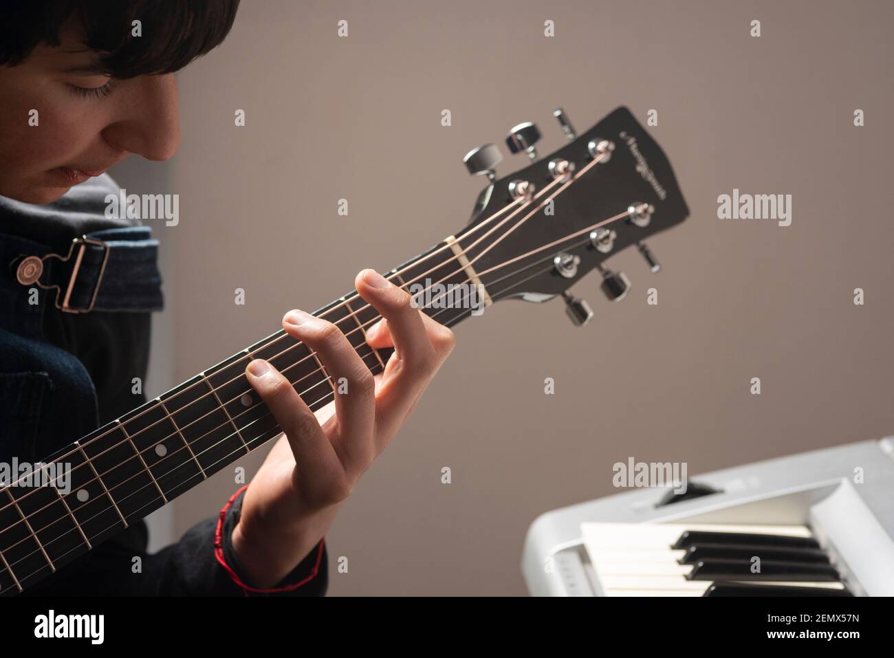 Close-up of teenage boy playing acoustic guitar,London,UK Stock Photo