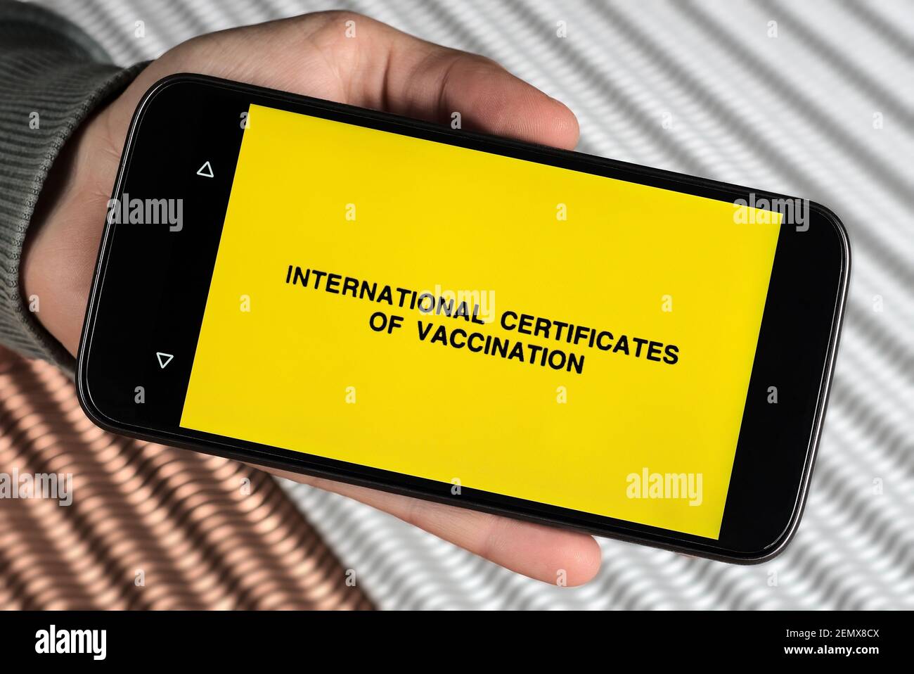 Person showing ' international certificates of vaccination' lettering on smartphone concept digital electronic immunisation vaccine record certificate Stock Photo