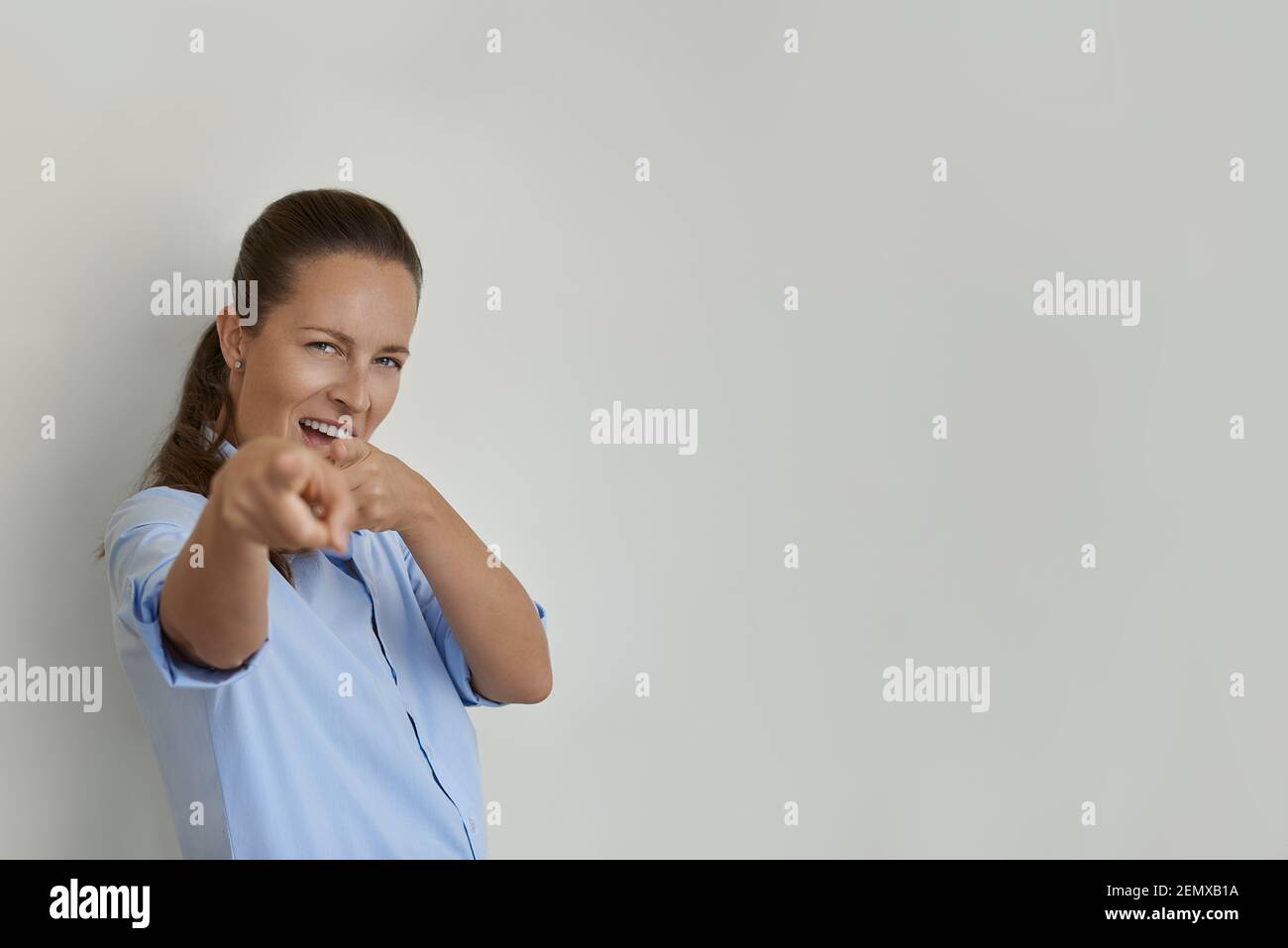 Woman winking and pointing with finger at camera Stock Photo