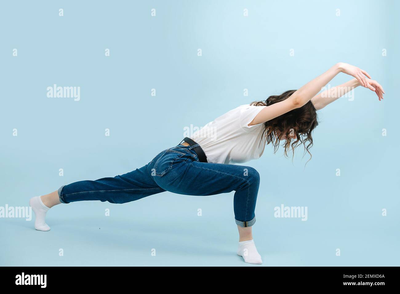 Expressive contemporary dancer lunging body forward, making wave like motions. Stock Photo