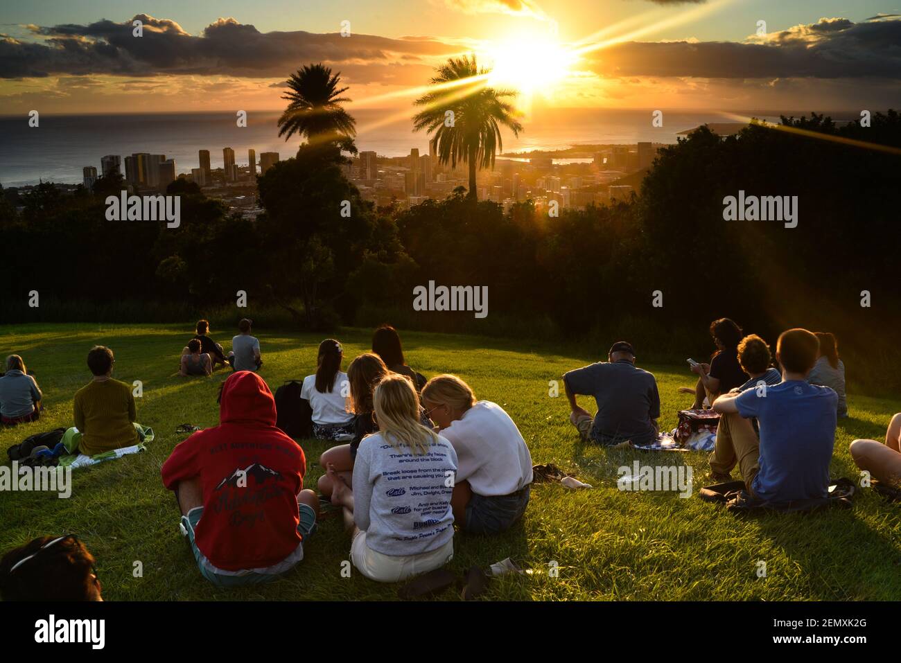 Tourists and Hawaiian people gathered to watch sunset from lookout at Mount Tantalus in Puu Ualakaa State Park, Oahu, Honolulu, Hawaii, USA Stock Photo