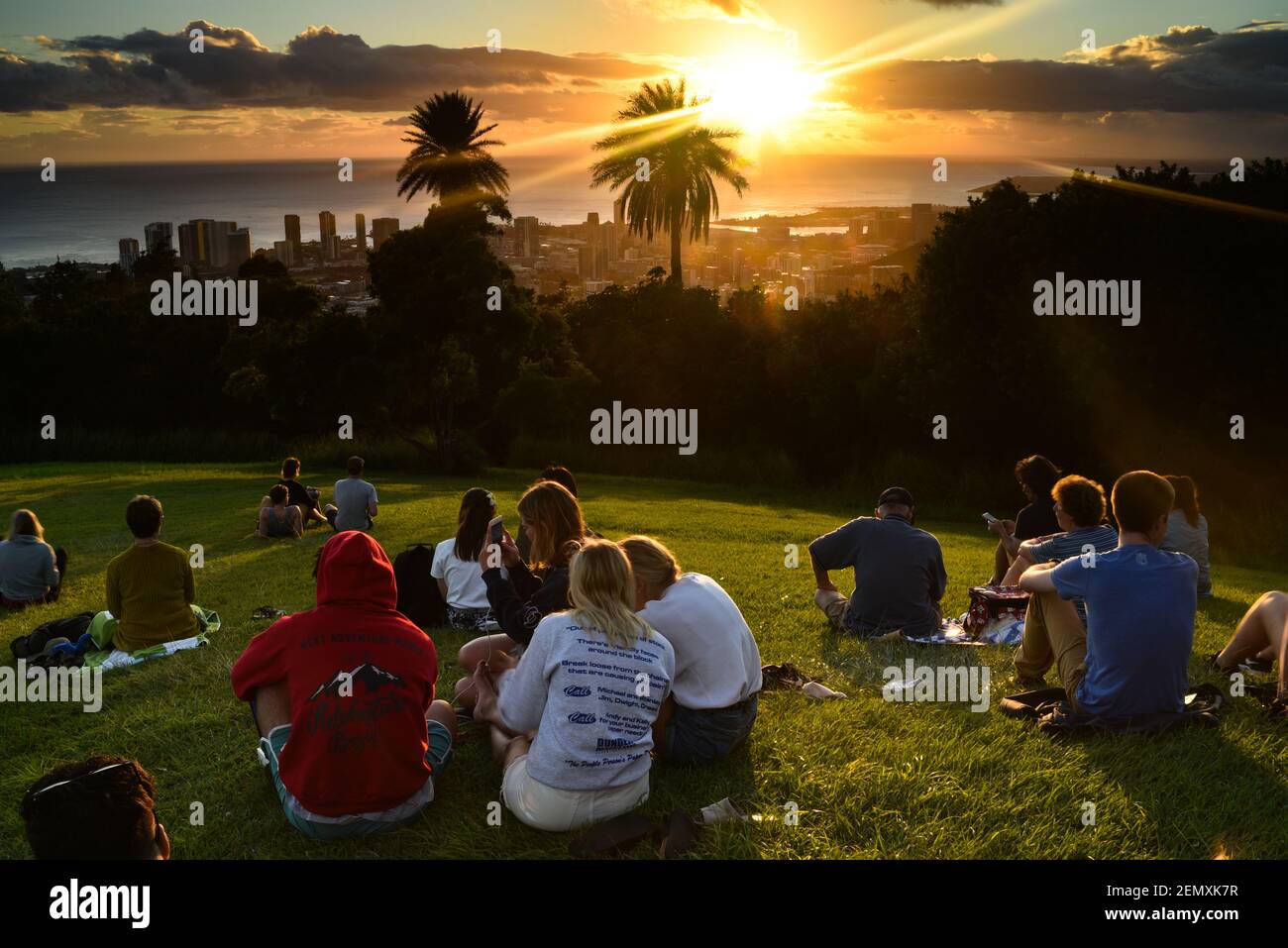 Tourists and Hawaiian people gathered to watch sunset from lookout at Mount Tantalus in Puu Ualakaa State Park, Oahu, Honolulu, Hawaii, USA Stock Photo