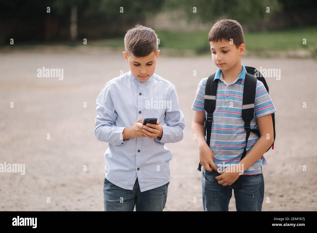 Two boys plays online games in quarantine. Young boys smile and use phone.  One look how play another Stock Photo - Alamy