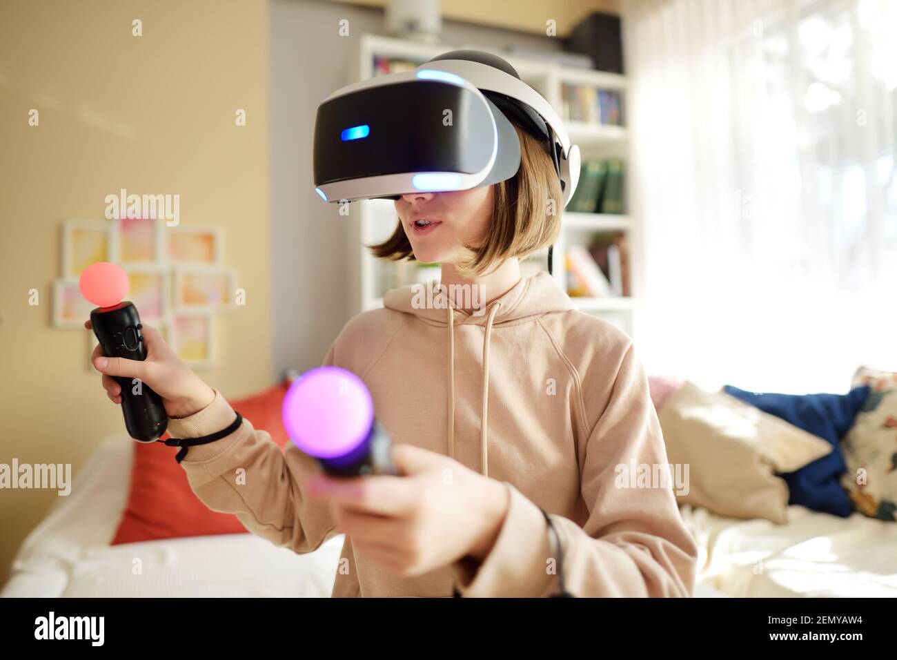Pretty teenage girl wearing virtual reality headset at home. Cute teen using VR glasses play a Child in virtual augmented reality helmet. Fut Stock Photo - Alamy