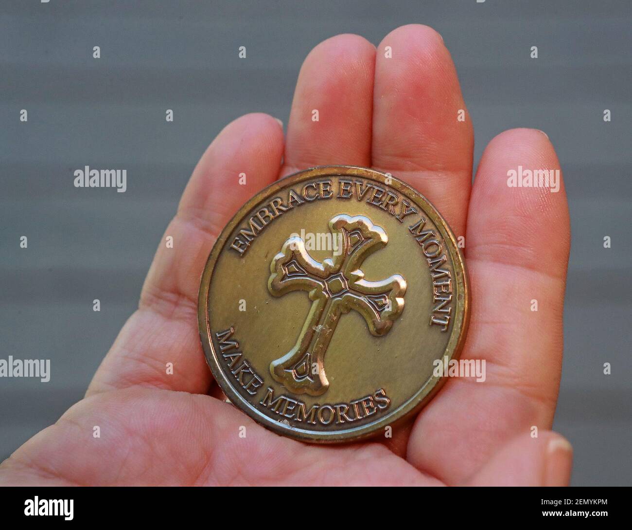 Tammy McCracken shows off the back of a challenge coin she had made to