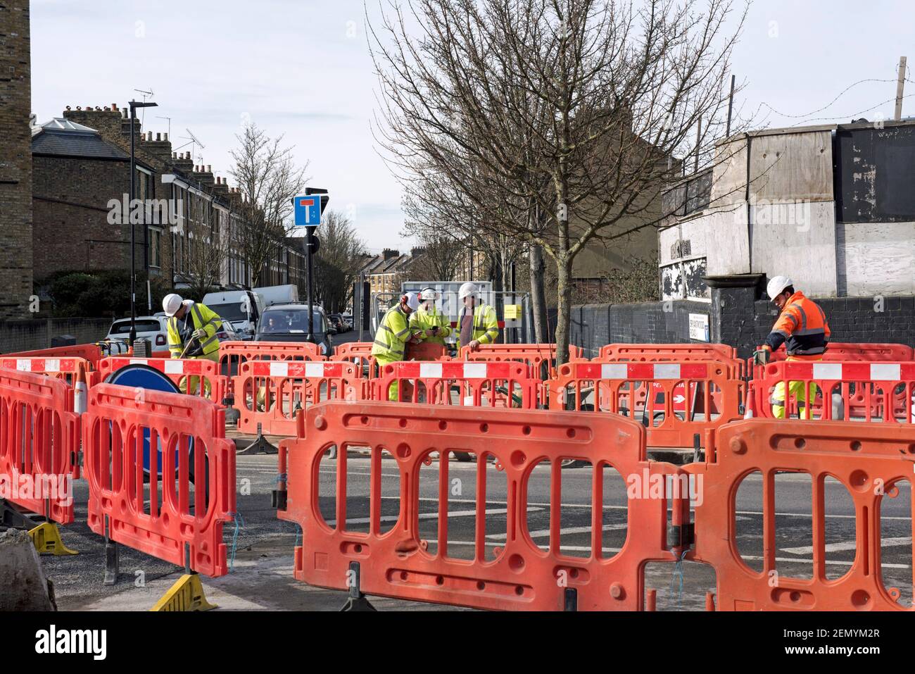 Road Works with layers of orange barriers and workmen constructing cycle lanes part of the low traffic neighbourhood scheme Drayton Park Highbury Stock Photo