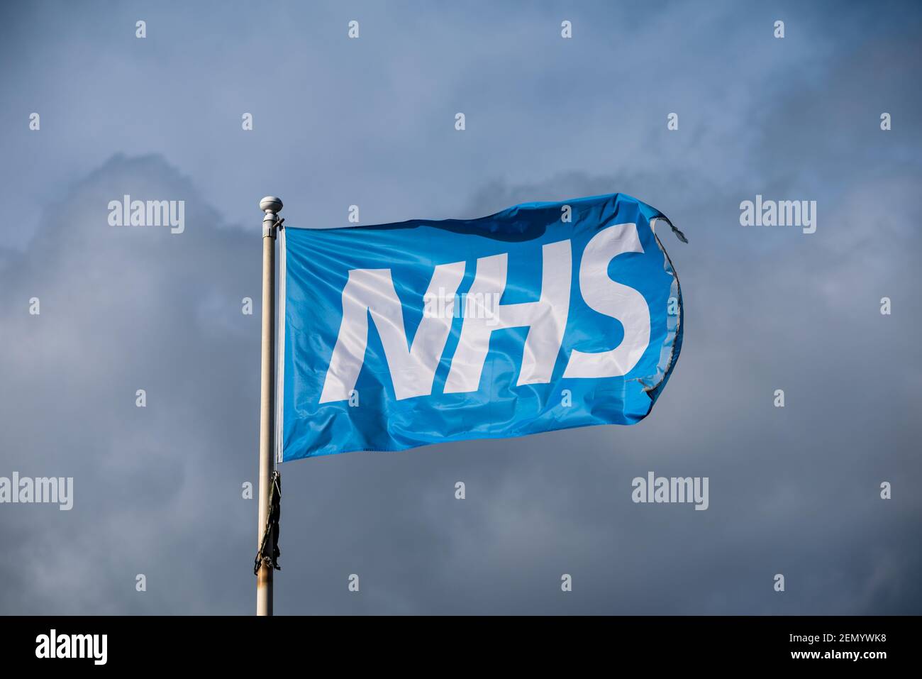 Waving blue NHS flag isolated in front of a cloudy sky Stock Photo