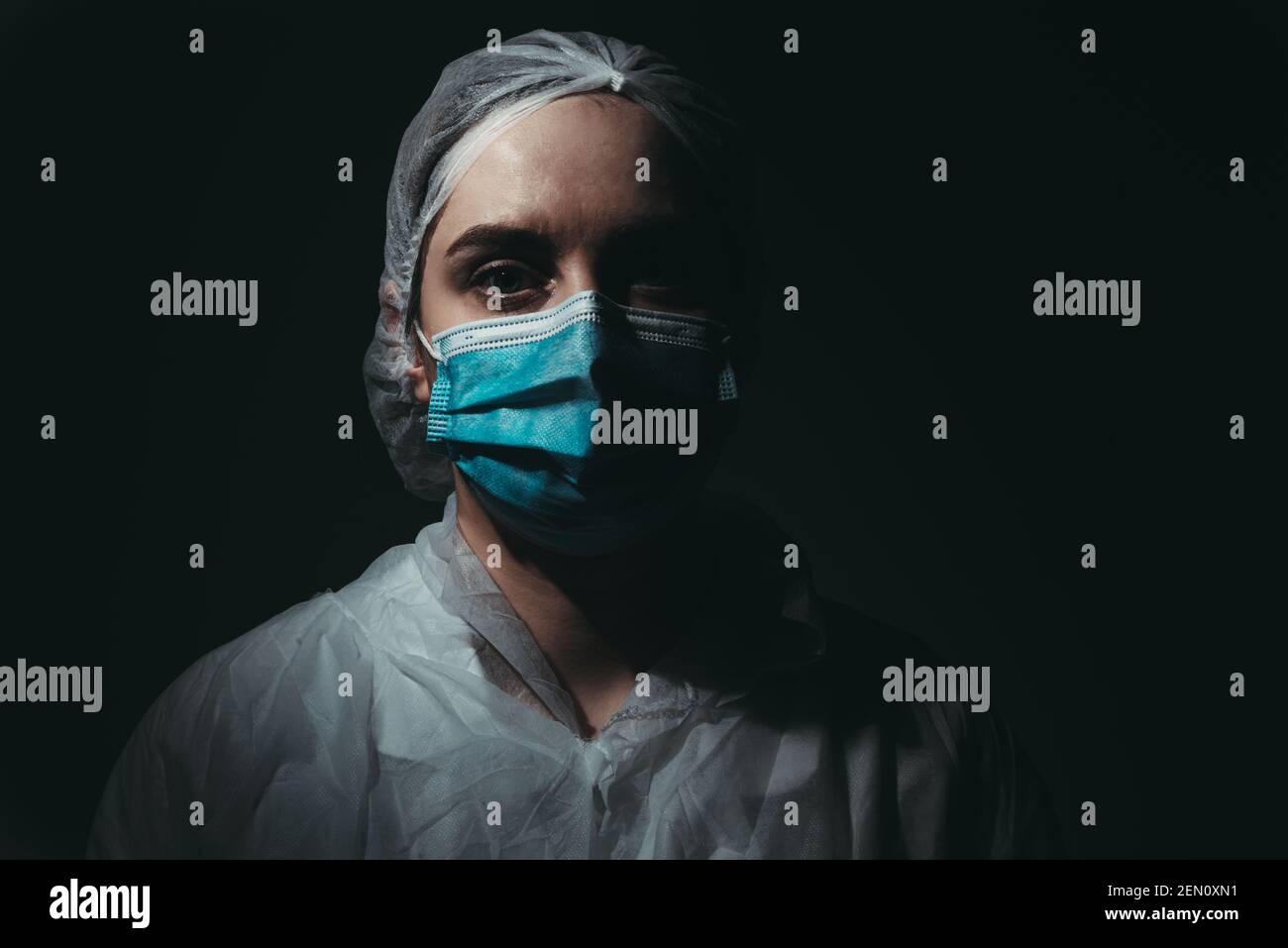 Medical worker wearing medical mask on black background Stock Photo