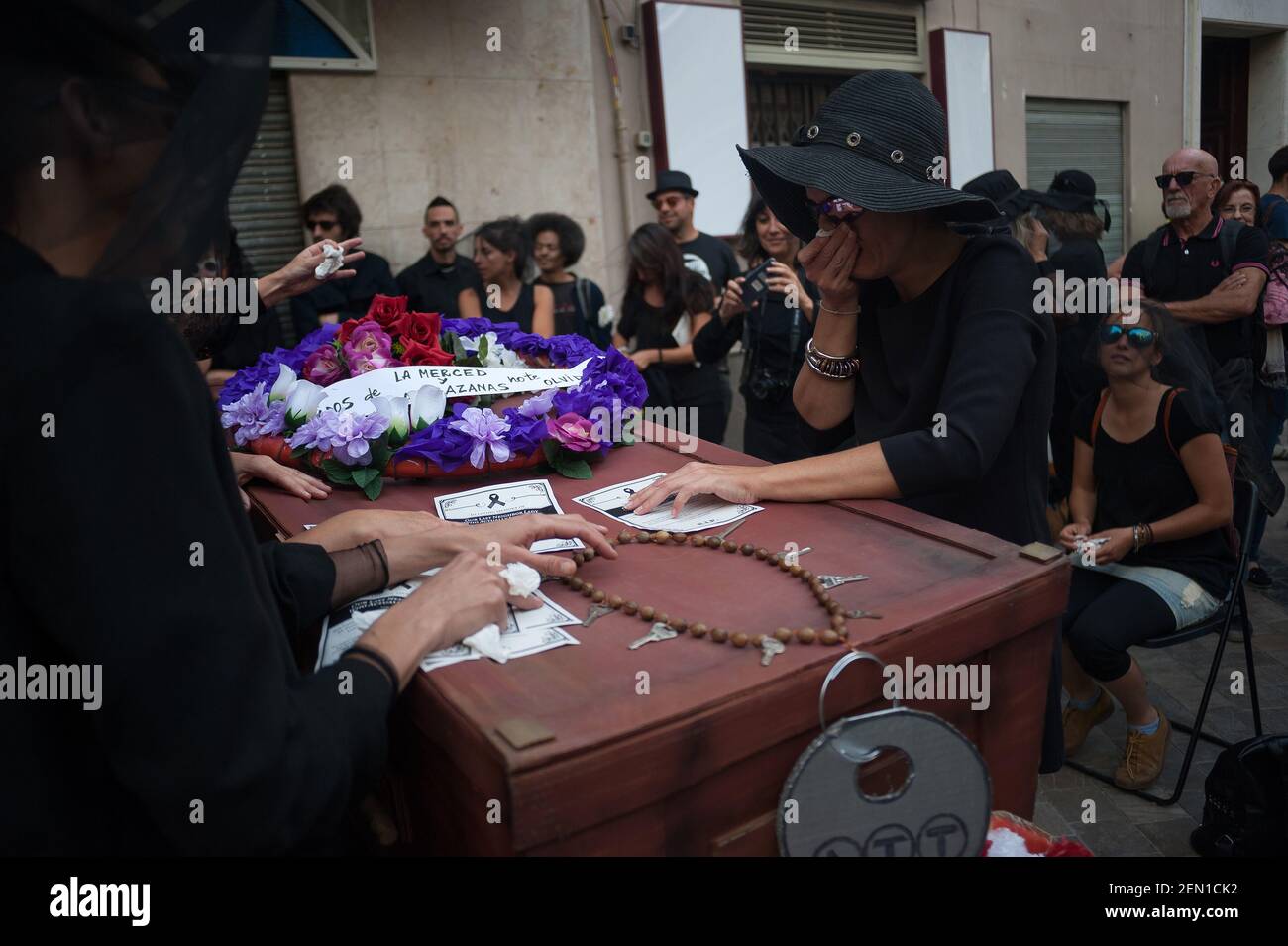 A group of women dressed in mourning clothes are seen crying next to a