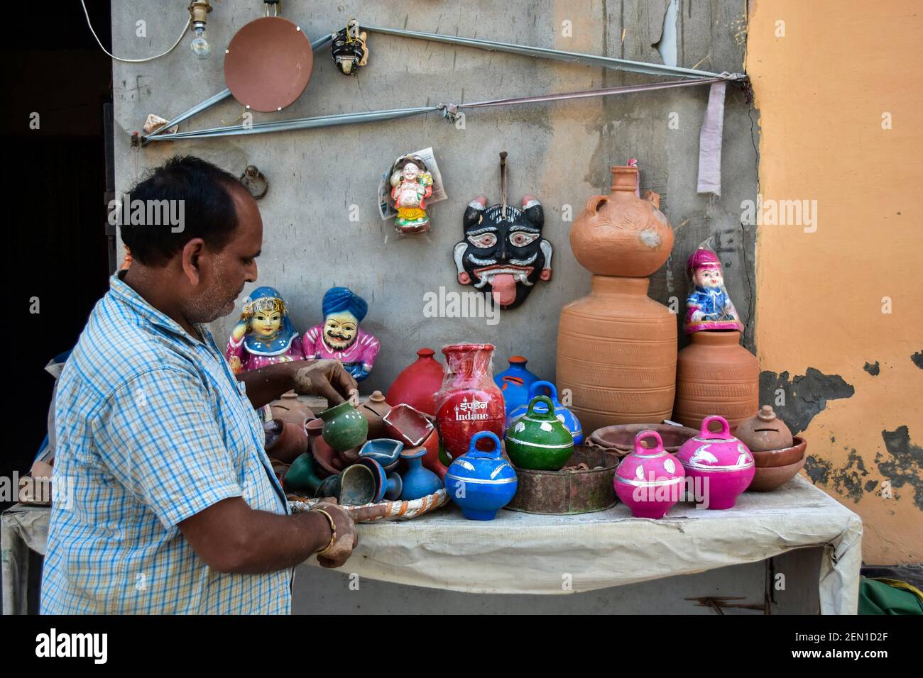 An Indian potter seen arranging pottery Items at his store in Patiala