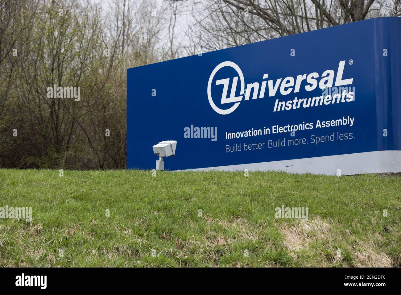A logo sign outside of the headquarters of Universal Instruments in