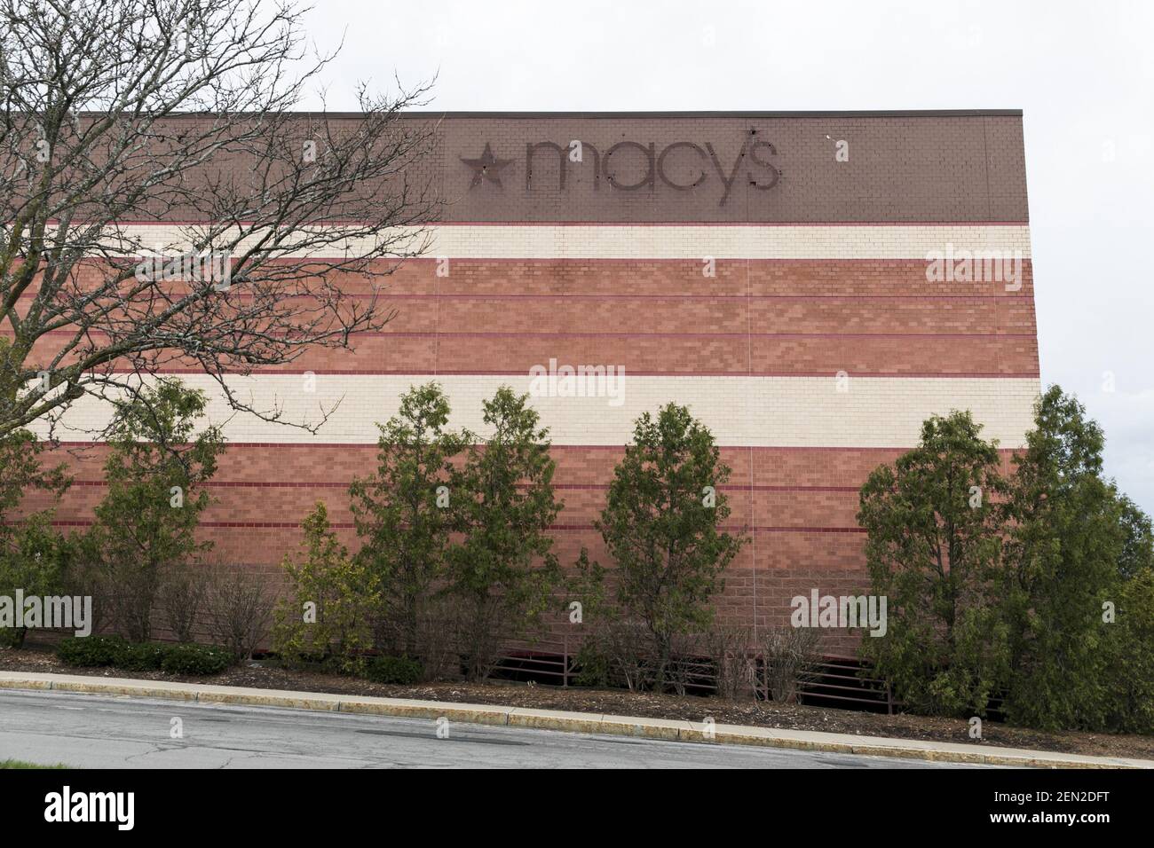 The outline of a Macy’s logo sign outside of a closed retail store