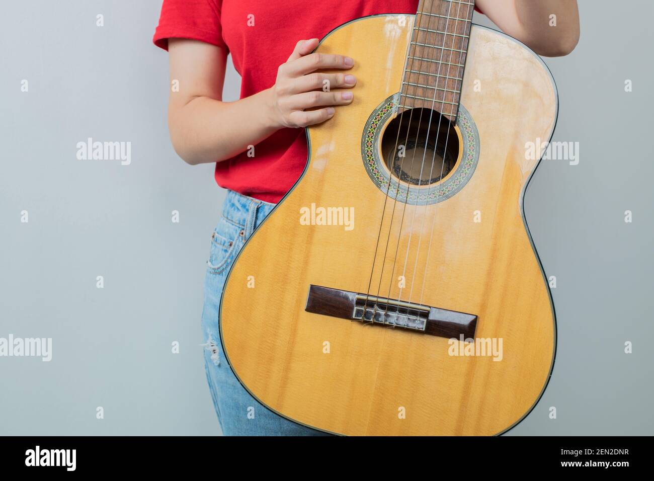 Young girl in red shirt holding an acoustic guitar Stock Photo - Alamy