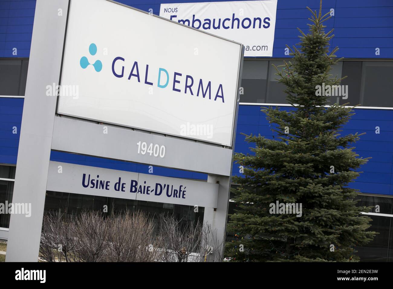 A logo sign outside of a facility occupied by Galderma in Baied’Urfé