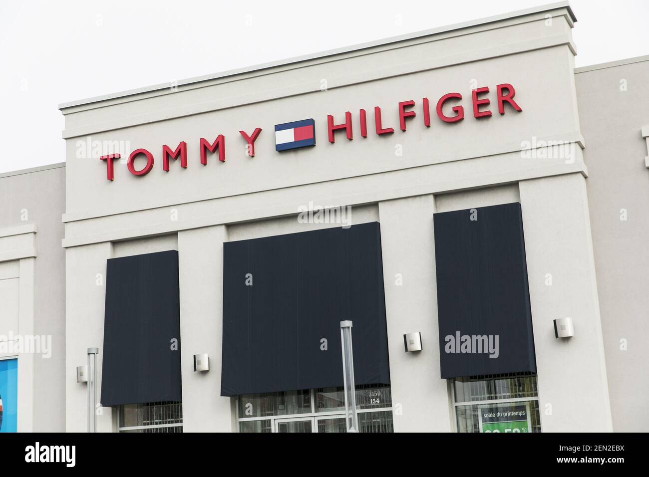 A logo sign outside of a Tommy Hilfiger retail store location in  Vaudreuil-Dorion, Quebec, Canada, on April 21, 2019. (Photo by Kristoffer  Tripplaar/Sipa USA Stock Photo - Alamy