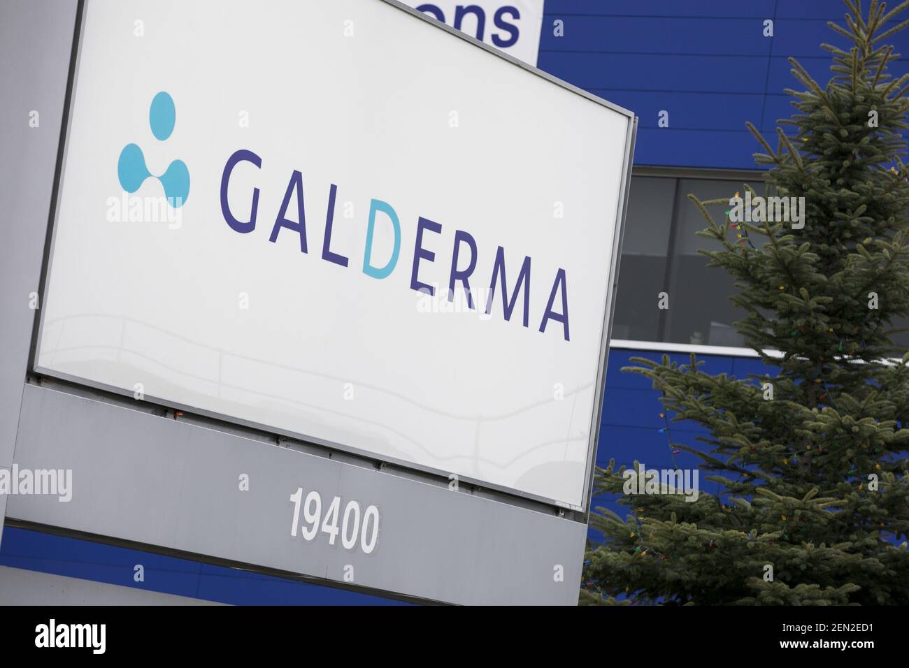 A logo sign outside of a facility occupied by Galderma in Baied’Urfé