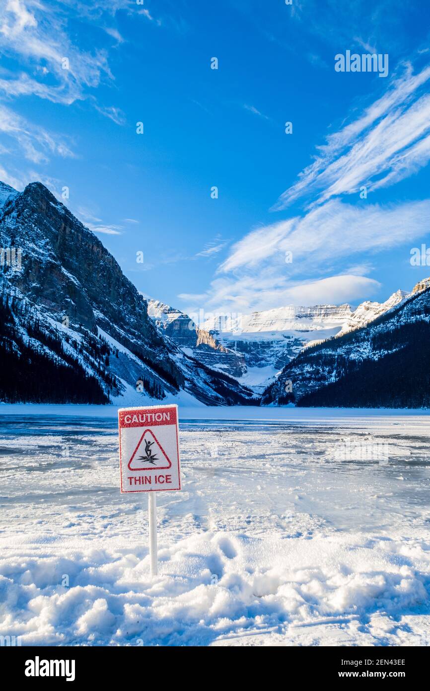 Warning sign 'Caution thin ice' in front of Lake Louise, Canada Stock Photo