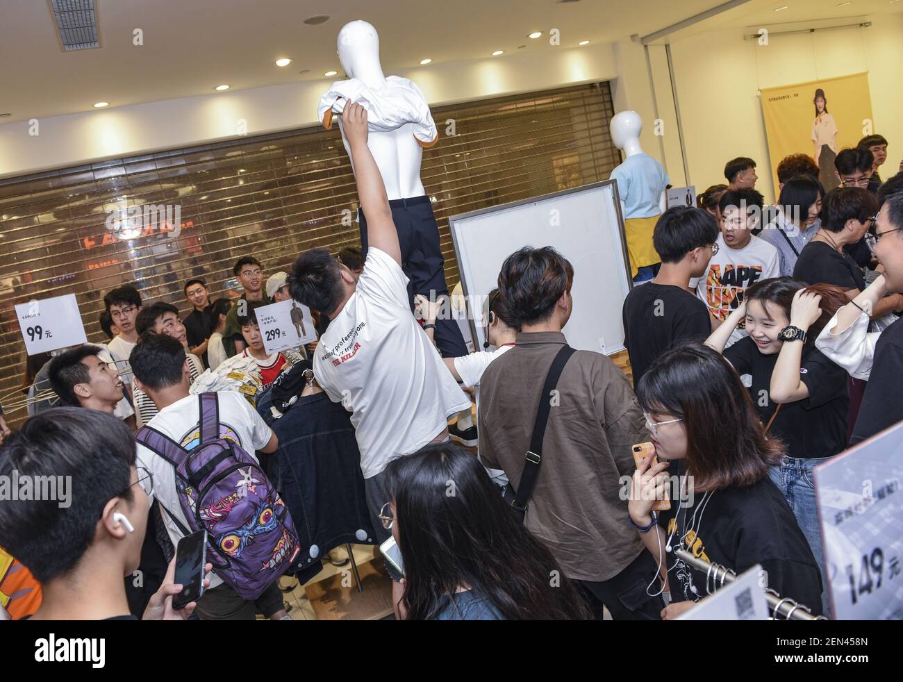 Chinese customers queue up in front of a Uniqlo store to buy the special  KAWS x Uniqlo UT collaborative capsule in Jinhua city, east China's  Zhejiang province, 3 June 2019. The special