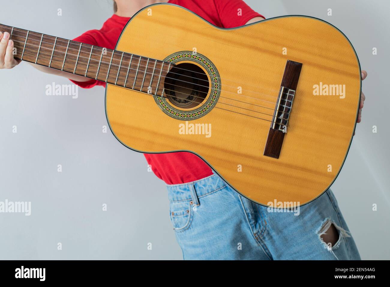 Young girl in red shirt holding an acoustic guitar Stock Photo - Alamy