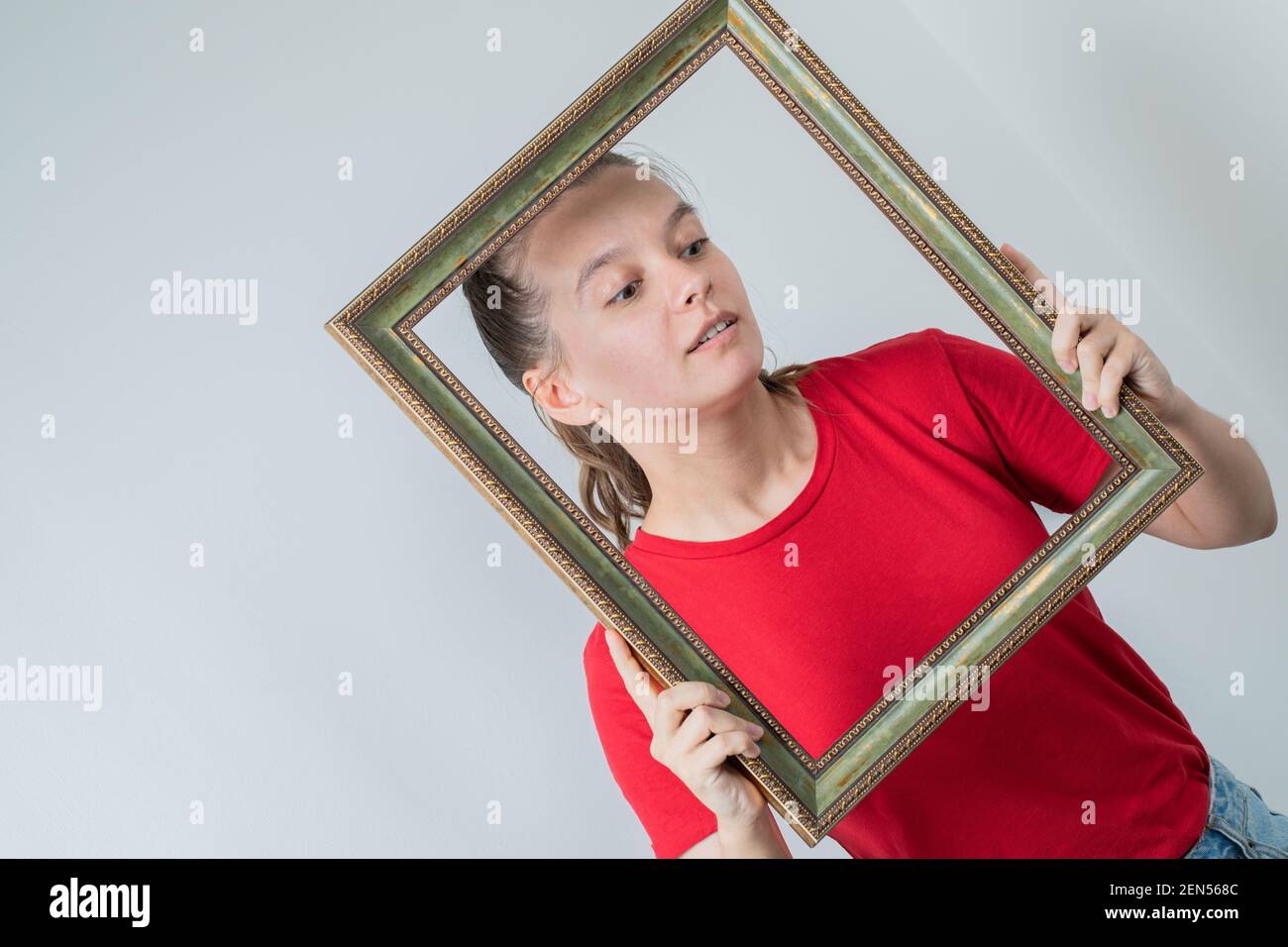 Female model in red shirt holding photo frames Stock Photo - Alamy