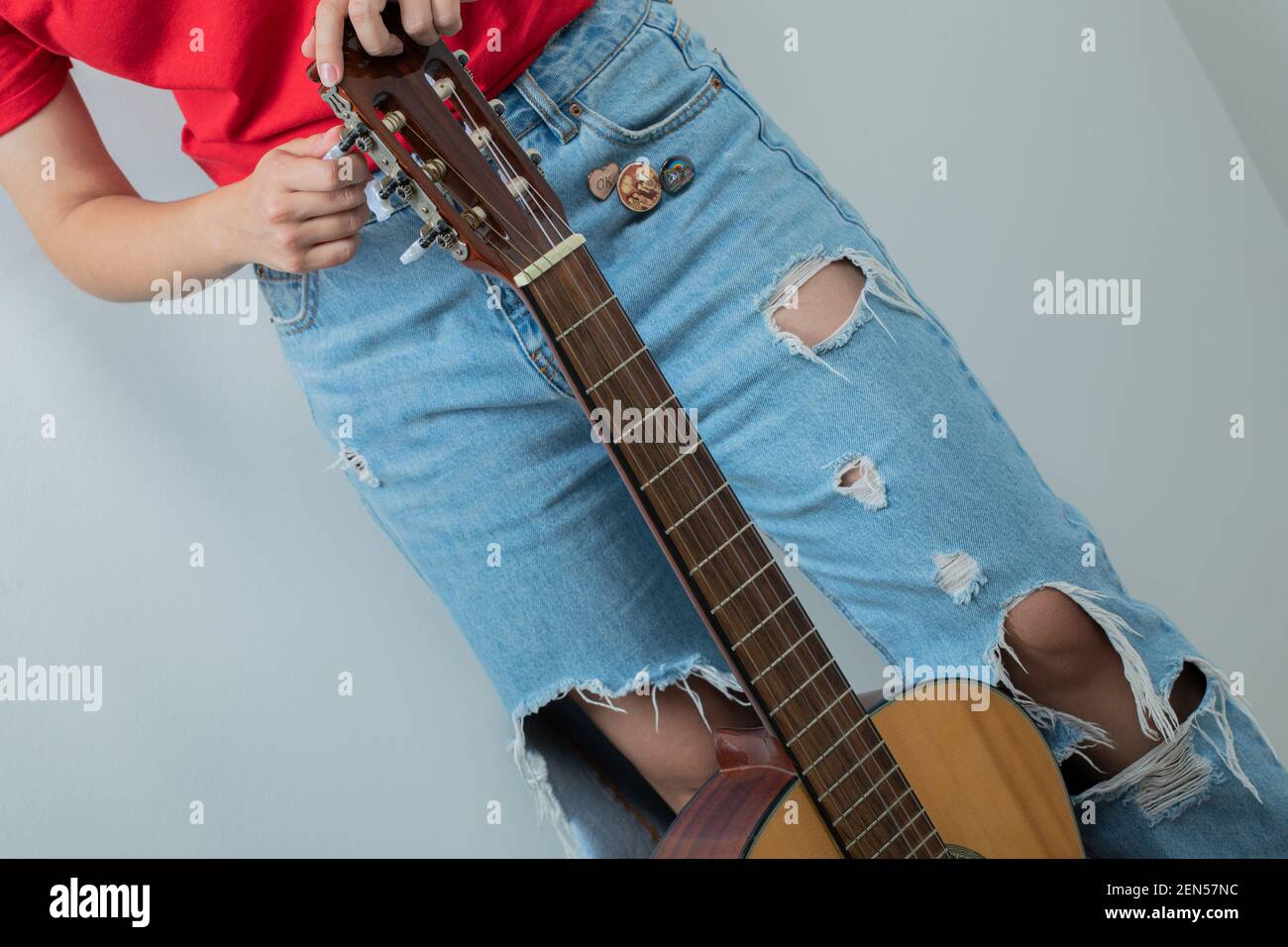 Female model holding a wooden guitar Stock Photo - Alamy