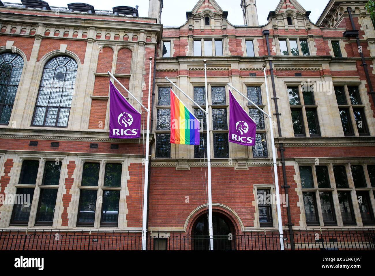 A Pride flag hangs in between RICS flags outside Royal Institution of Chartered Surveyors (RICS ) building in central London in celebration of Pride in London next month. (Photo by Dinendra Haria / SOPA Images/Sipa USA) Stock Photo