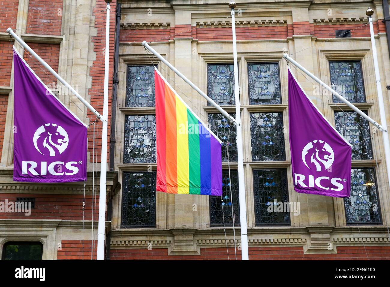 A Pride flag hangs in between RICS flags outside Royal Institution of Chartered Surveyors (RICS ) building in central London in celebration of Pride in London next month. (Photo by Dinendra Haria / SOPA Images/Sipa USA) Stock Photo
