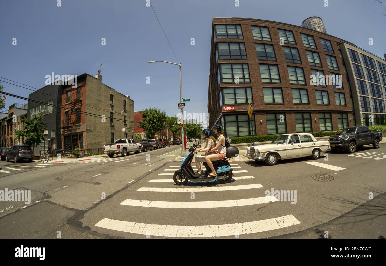 Women travel on an electric moped from the moped sharing company Revel