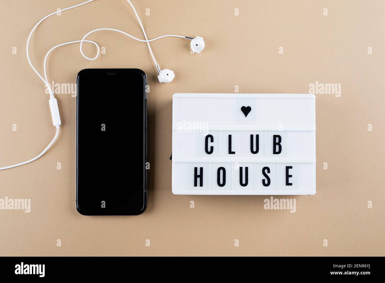 Astana, Kazakhstan - February, 17, 2021: Smartphone, headphones lightbox with text Clubhouse flat lay Stock Photo