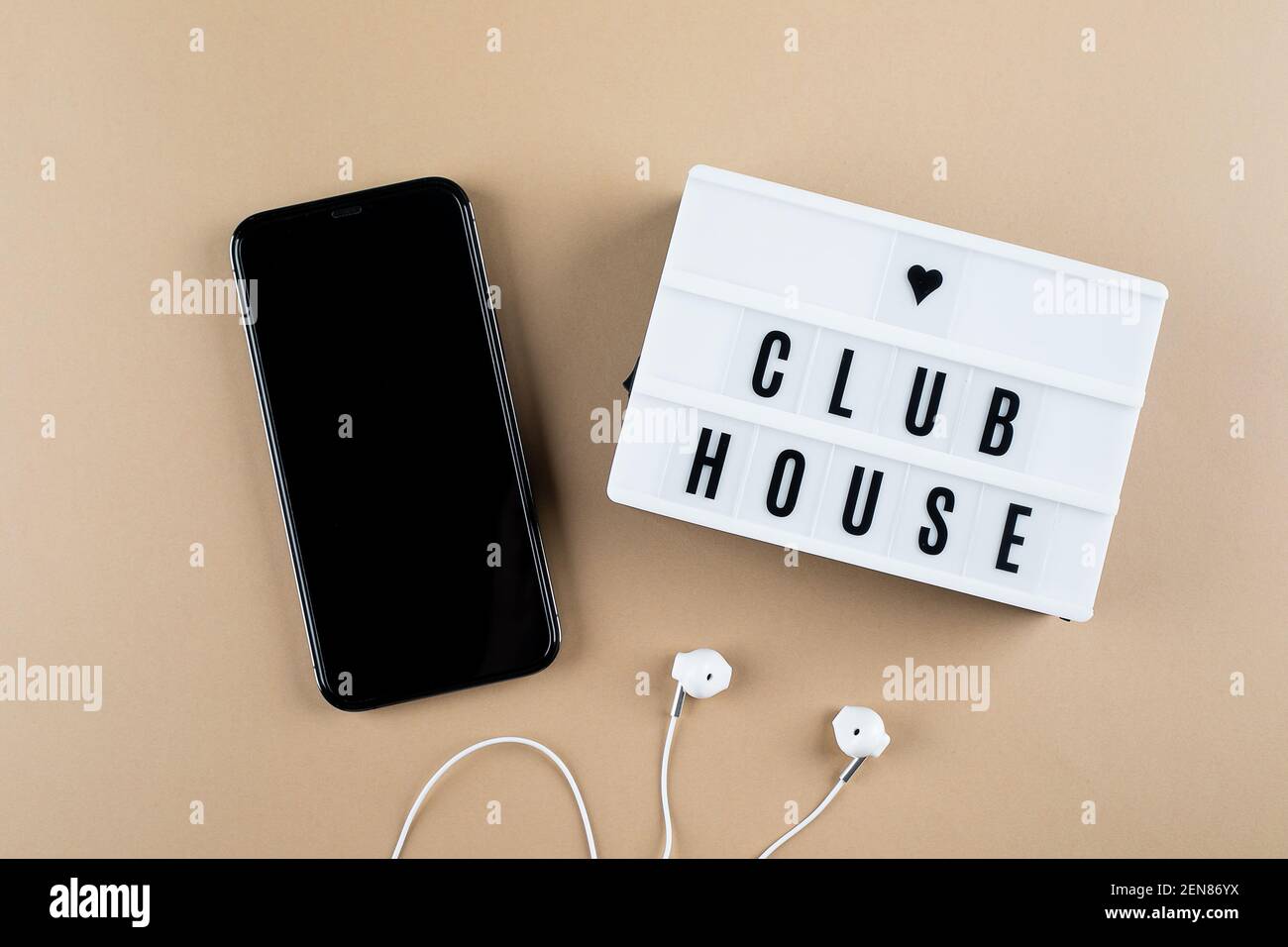 Astana, Kazakhstan - February, 17, 2021: Smartphone, headphones lightbox with text Clubhouse flat lay Stock Photo