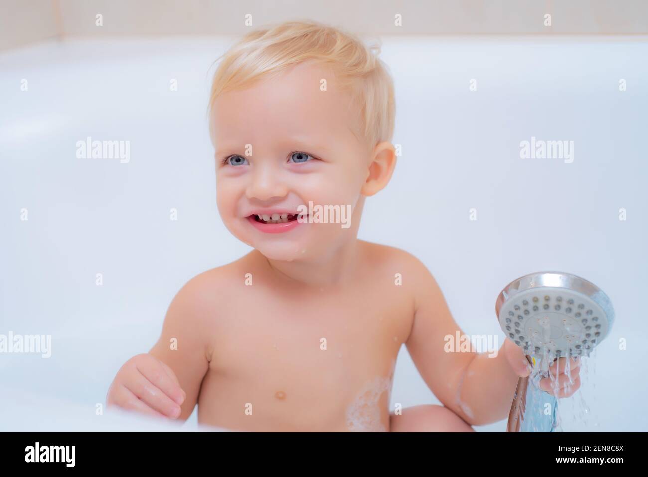 Smiling baby in bath. Funny kids fun bathtub. Hygiene and kids care