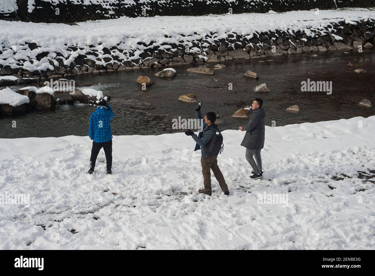 29.12.2017, Takayama, Gifu, Japan, Asia - A group of young men enjoy a snowball fight along the banks of the Miyagawa River. Stock Photo