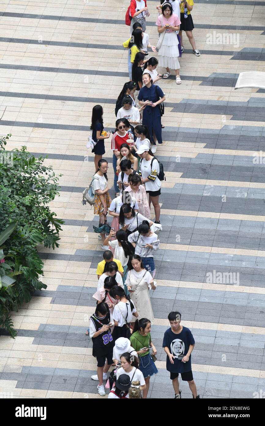 Chinese fans wait in a long queue in front of a milk tea store operated ...