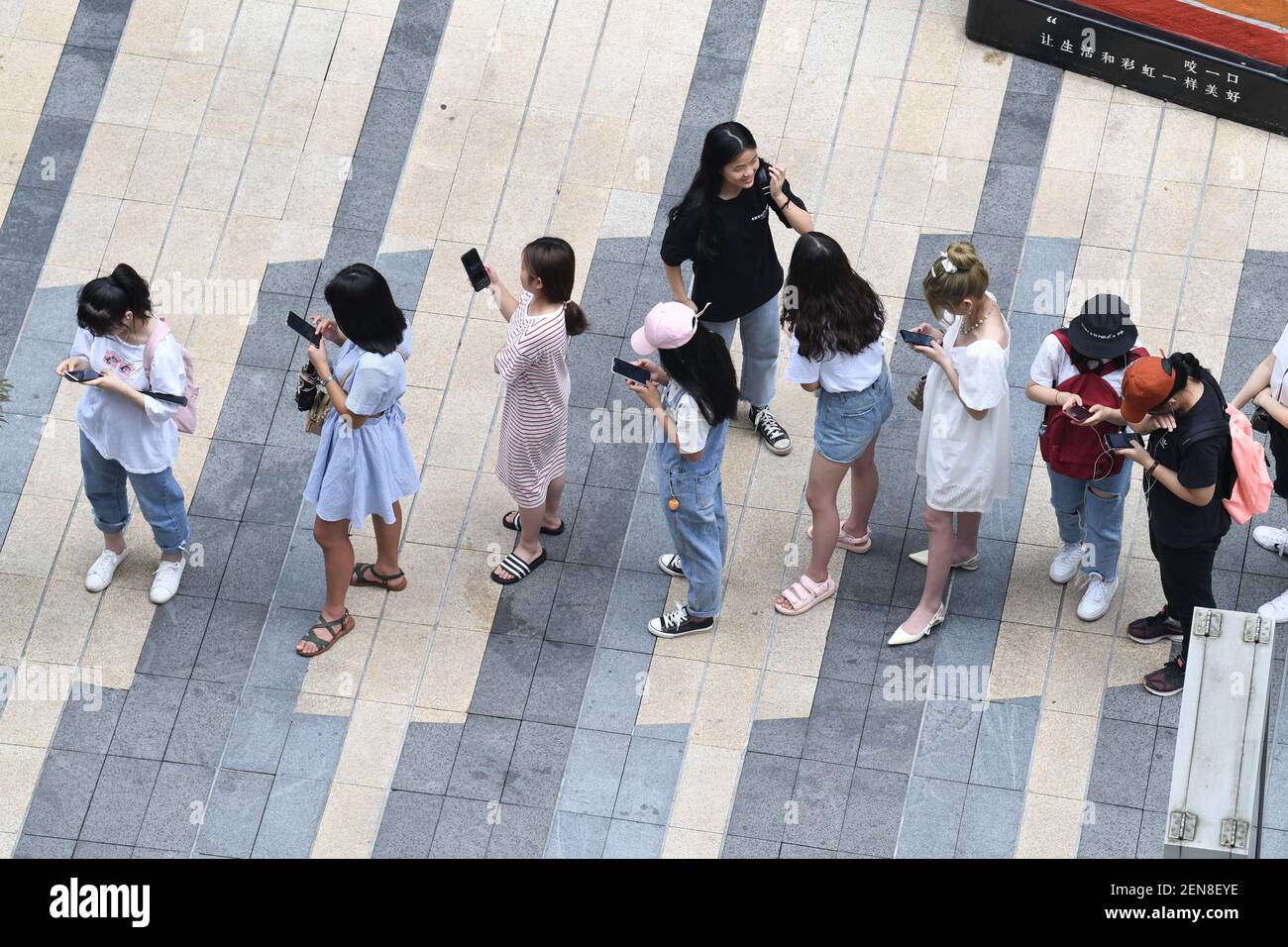 Chinese fans wait in a long queue in front of a milk tea store operated ...