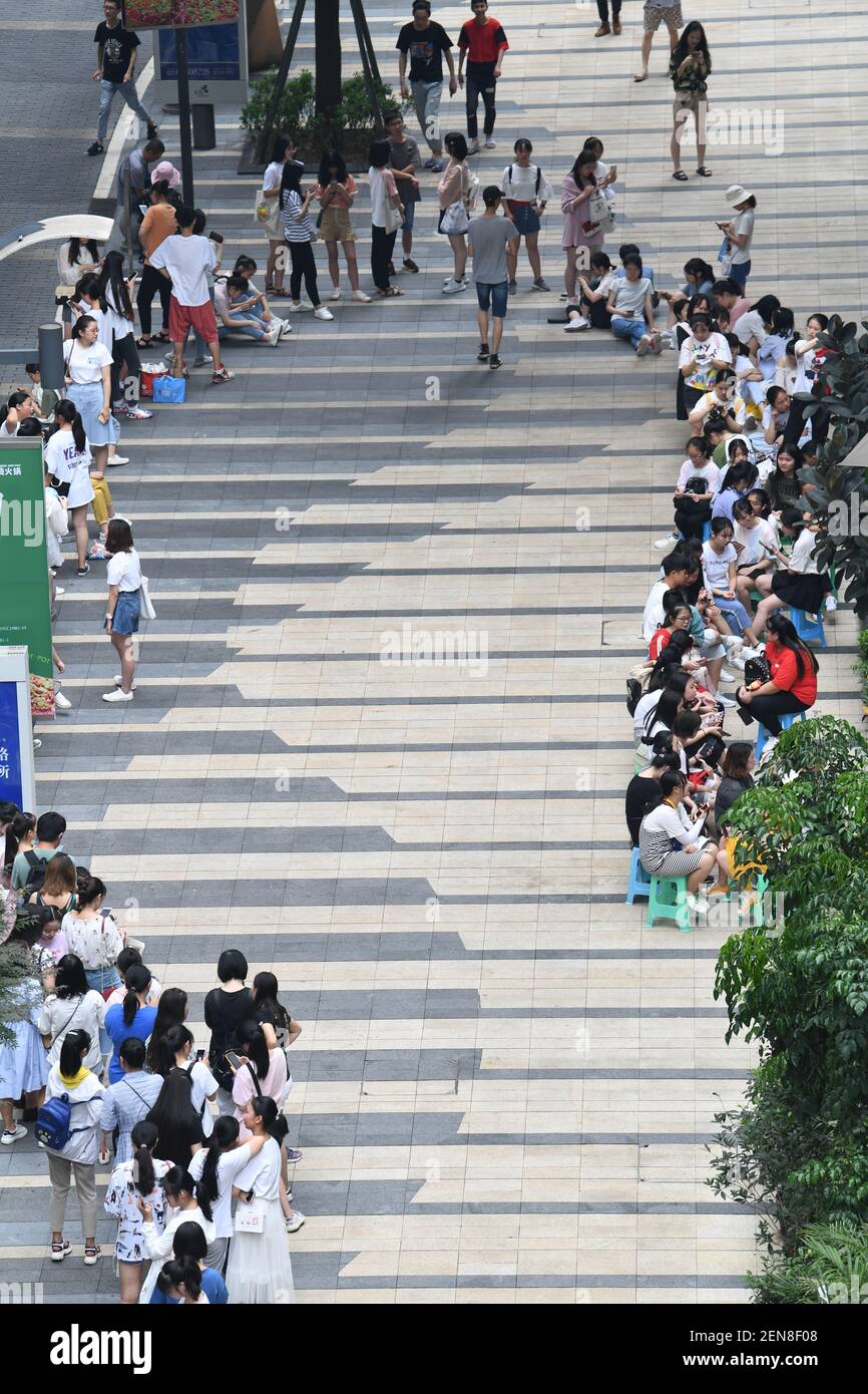 Chinese fans wait in a long queue in front of a milk tea store operated ...