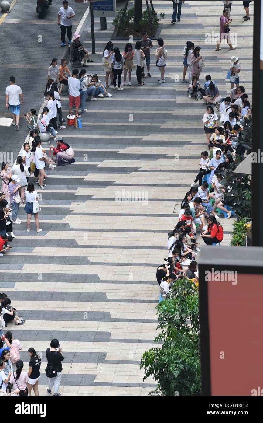 Chinese fans wait in a long queue in front of a milk tea store operated ...